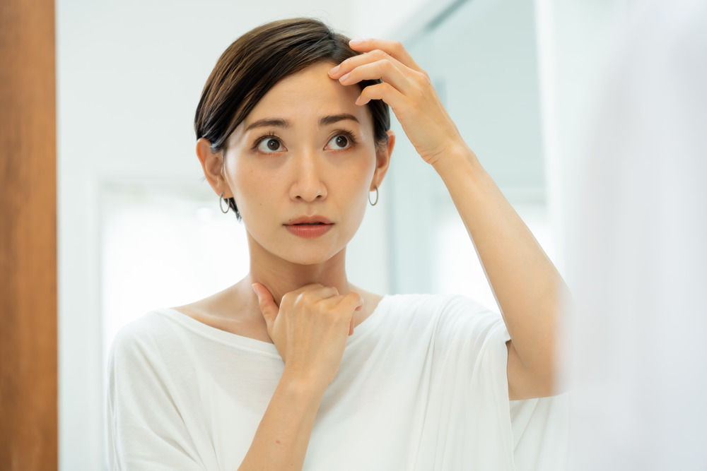 鏡を見ながら髪の変化を確認する女性